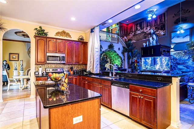 kitchen featuring sink, stainless steel appliances, light tile patterned floors, decorative backsplash, and a kitchen island