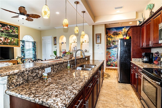 kitchen featuring appliances with stainless steel finishes, ceiling fan, sink, pendant lighting, and stone counters