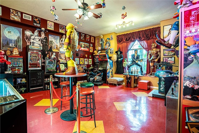 playroom featuring ceiling fan and a textured ceiling