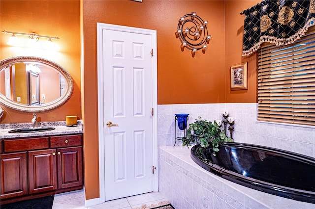 bathroom with tile patterned flooring, vanity, and a relaxing tiled tub