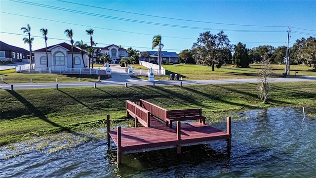 view of dock featuring a lawn and a water view