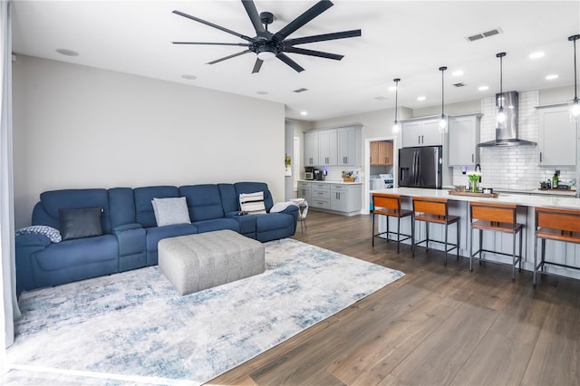 living room with ceiling fan and dark wood-type flooring