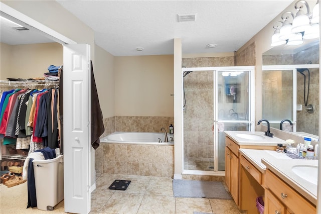 bathroom featuring tile patterned flooring, vanity, a textured ceiling, and shower with separate bathtub