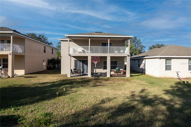 back of house with a balcony, a yard, and a patio