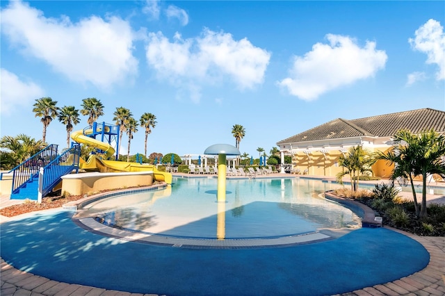 view of pool featuring a patio, a playground, and a water slide