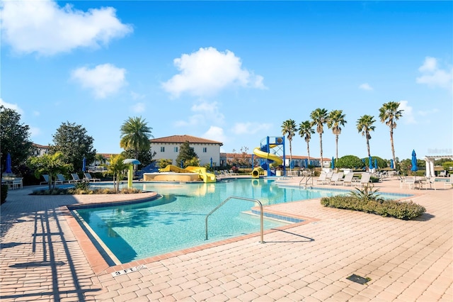 view of swimming pool with a patio and a water slide