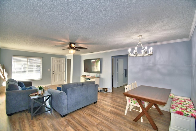 living room featuring dark hardwood / wood-style flooring, ceiling fan with notable chandelier, a textured ceiling, and ornamental molding