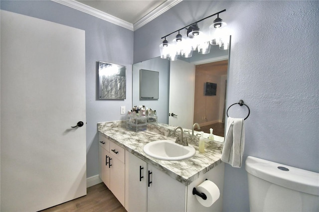 bathroom featuring hardwood / wood-style floors, vanity, toilet, and ornamental molding