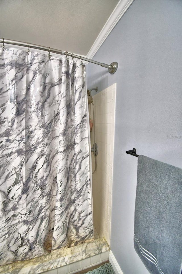 bathroom featuring a shower with curtain, a textured ceiling, and ornamental molding