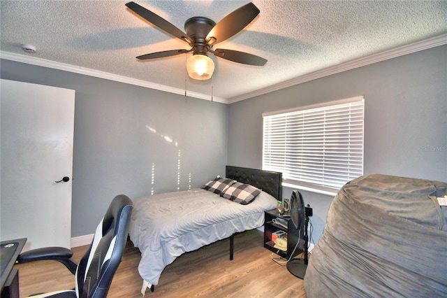 bedroom with ceiling fan, crown molding, wood-type flooring, and a textured ceiling