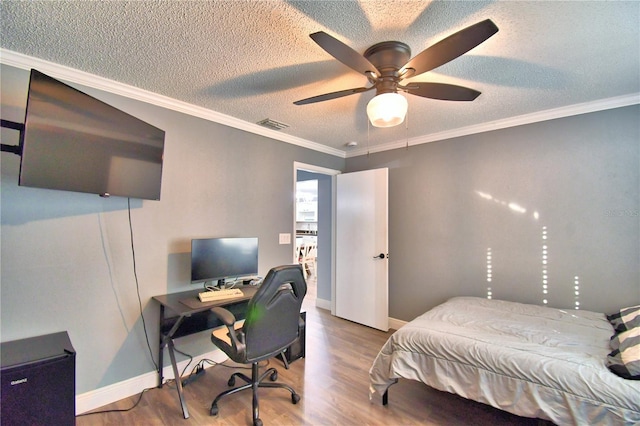 bedroom featuring a textured ceiling, ceiling fan, hardwood / wood-style flooring, and ornamental molding