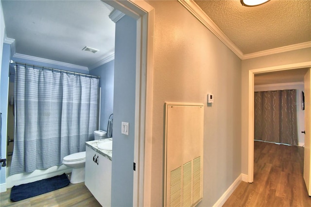 full bathroom with shower / bath combination with curtain, wood-type flooring, a textured ceiling, vanity, and ornamental molding