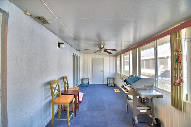 sunroom / solarium featuring ceiling fan