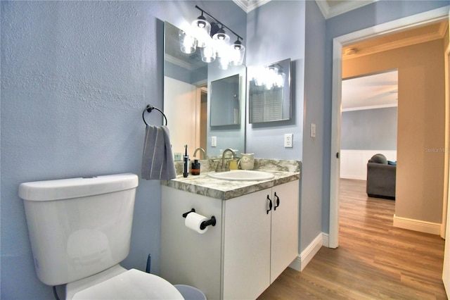 bathroom with vanity, toilet, wood-type flooring, and crown molding