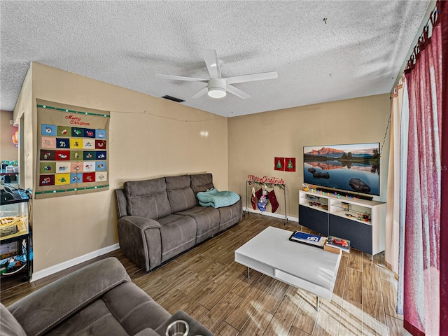 living room featuring ceiling fan and a textured ceiling