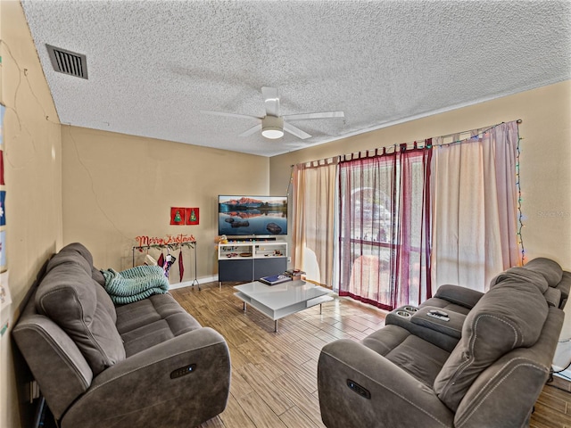 living room with wood-type flooring, a textured ceiling, and ceiling fan