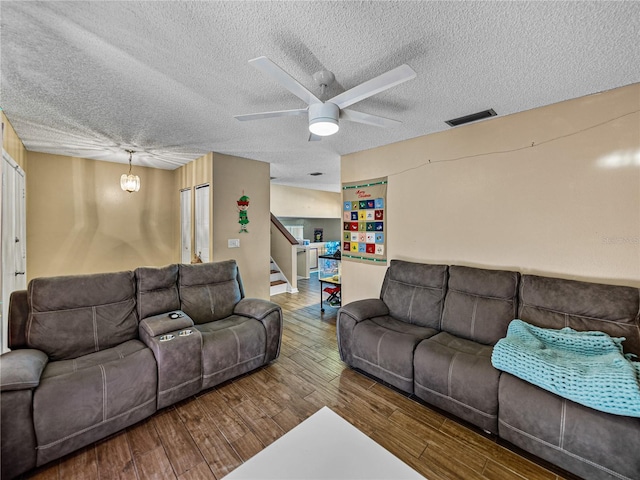 living room with hardwood / wood-style floors, a textured ceiling, and ceiling fan