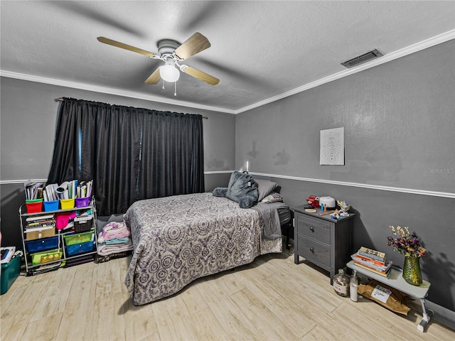 bedroom with a textured ceiling, hardwood / wood-style flooring, ceiling fan, and crown molding