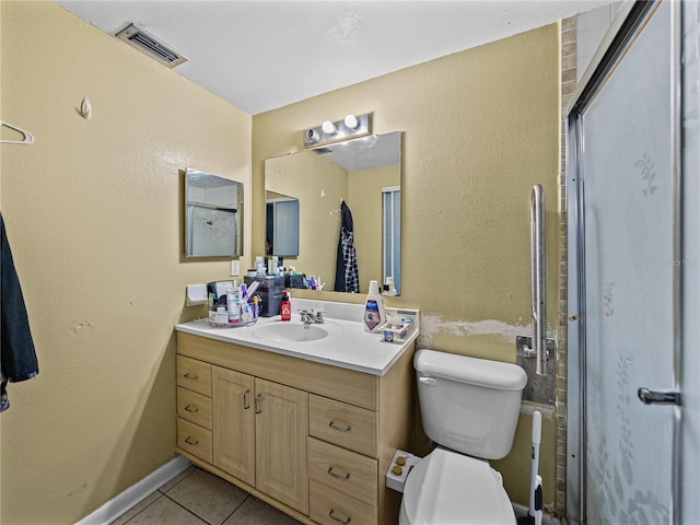 bathroom featuring tile patterned floors, vanity, toilet, and walk in shower