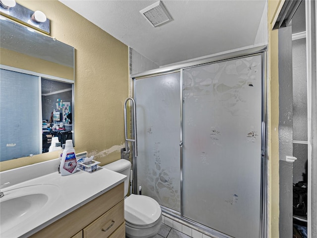 bathroom featuring vanity, tile patterned floors, toilet, a textured ceiling, and a shower with shower door