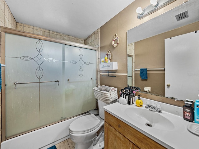 full bathroom with vanity, enclosed tub / shower combo, and toilet