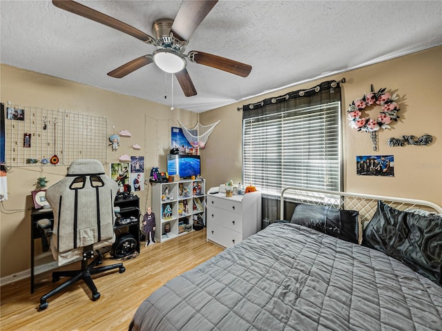 bedroom featuring a textured ceiling, hardwood / wood-style flooring, and ceiling fan