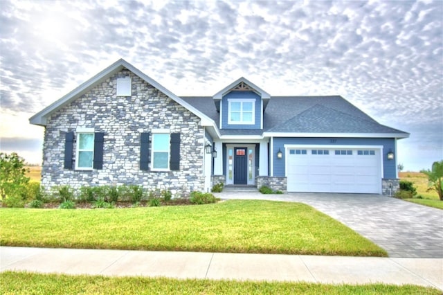 view of front facade featuring a garage, stone siding, a front lawn, and decorative driveway