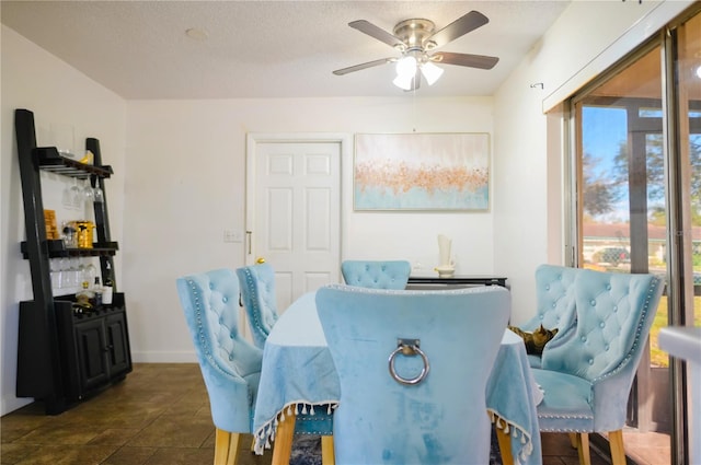 dining space featuring ceiling fan and a textured ceiling