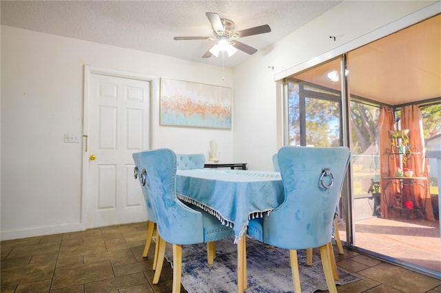 dining area featuring ceiling fan and a textured ceiling