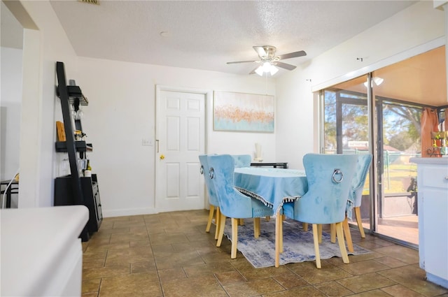 dining space featuring a textured ceiling and ceiling fan