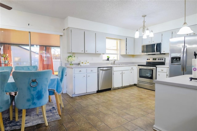 kitchen featuring white cabinetry, an inviting chandelier, hanging light fixtures, and appliances with stainless steel finishes