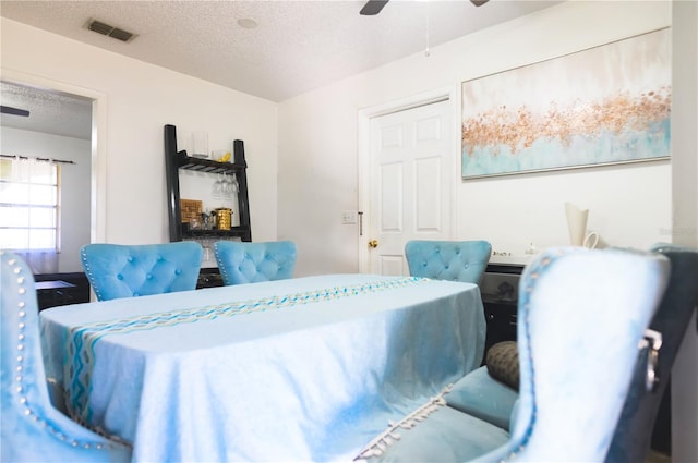 dining room with ceiling fan and a textured ceiling