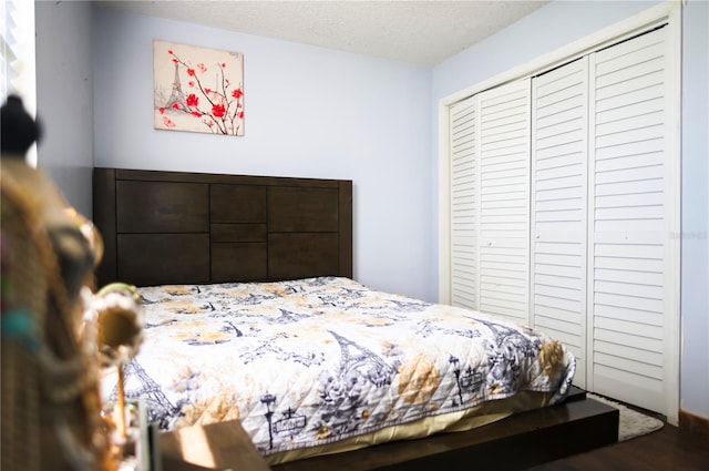 bedroom with a textured ceiling, hardwood / wood-style flooring, and a closet