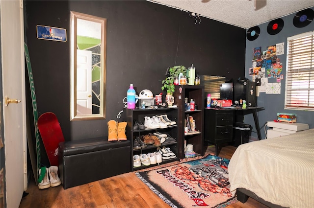 bedroom with a textured ceiling and hardwood / wood-style flooring