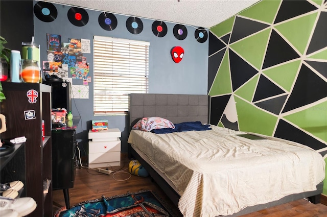 bedroom featuring wood-type flooring and a textured ceiling