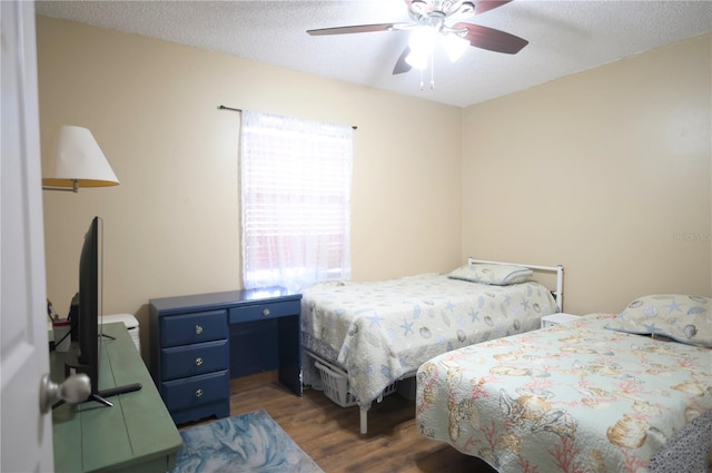 bedroom with ceiling fan, dark hardwood / wood-style flooring, and a textured ceiling