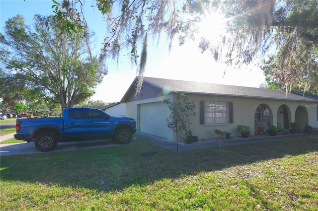 view of side of home featuring a lawn and a garage