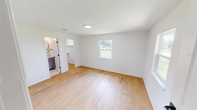 unfurnished bedroom with connected bathroom and light hardwood / wood-style floors