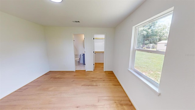 empty room with a wealth of natural light and light wood-type flooring