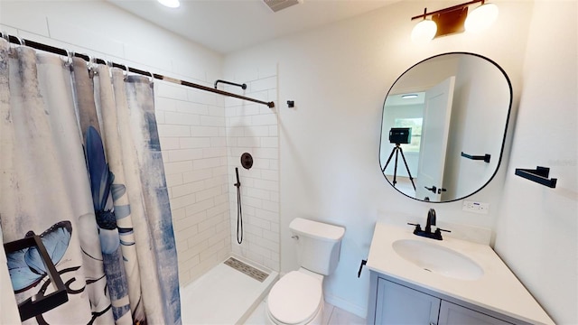 bathroom with toilet, vanity, and walk in shower