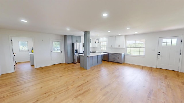 kitchen featuring pendant lighting, a center island, gray cabinetry, and light hardwood / wood-style flooring