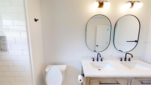 bathroom with vanity, toilet, and tiled shower