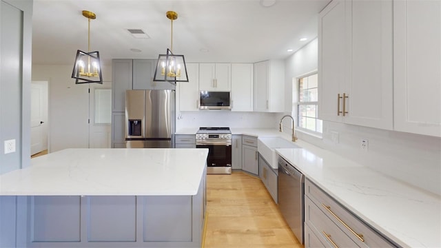 kitchen featuring gray cabinets, light stone countertops, sink, and appliances with stainless steel finishes