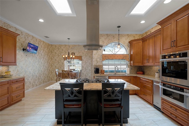 kitchen with a kitchen island, sink, ornamental molding, light stone counters, and a breakfast bar area