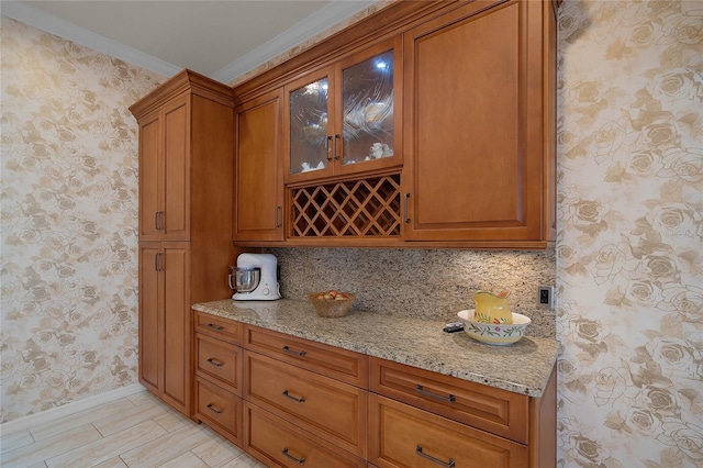 kitchen with crown molding, backsplash, and light stone countertops