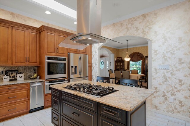 kitchen with light stone counters, crown molding, appliances with stainless steel finishes, and island range hood