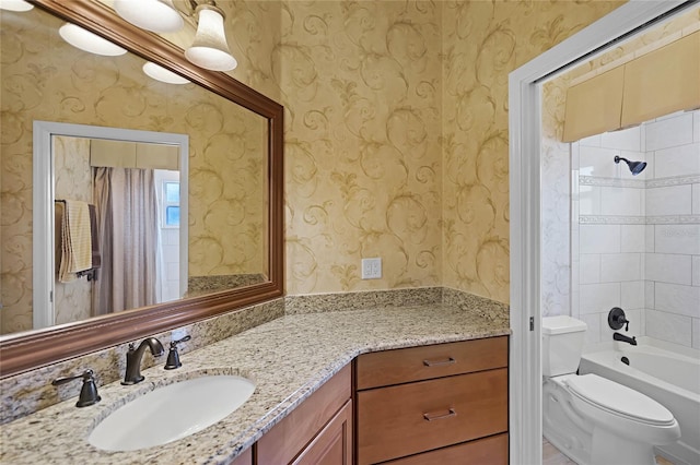 full bathroom featuring toilet, tiled shower / bath combo, and vanity