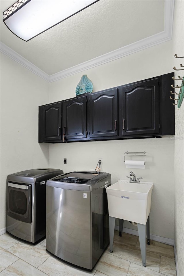 clothes washing area featuring cabinets, ornamental molding, and independent washer and dryer