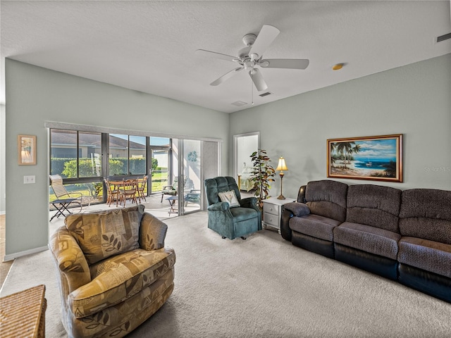 living room featuring ceiling fan, carpet flooring, and a textured ceiling