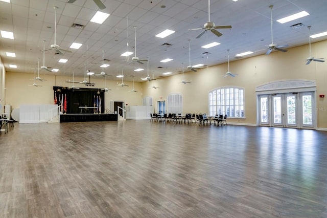 exercise area with dark wood-type flooring and a towering ceiling